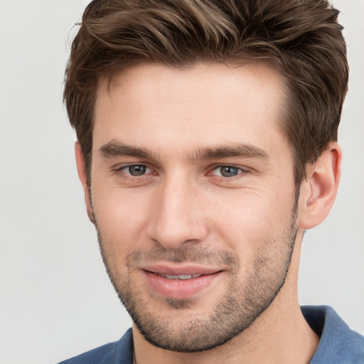 Joyful white young-adult male with short  brown hair and grey eyes