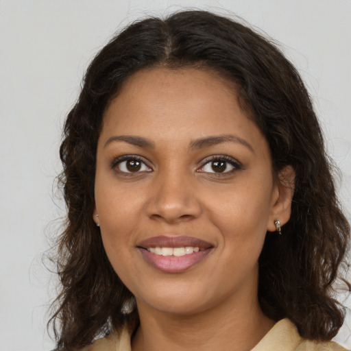 Joyful black young-adult female with long  brown hair and brown eyes