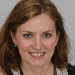 Joyful white adult female with medium  brown hair and grey eyes