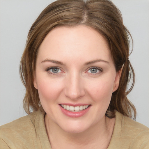 Joyful white young-adult female with medium  brown hair and blue eyes