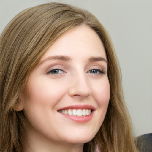 Joyful white young-adult female with long  brown hair and blue eyes