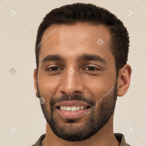 Joyful white young-adult male with short  black hair and brown eyes