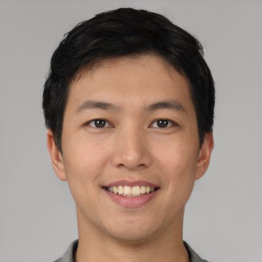 Joyful asian young-adult male with short  black hair and brown eyes