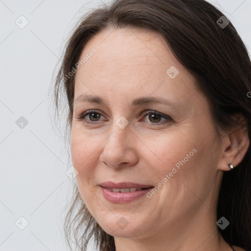 Joyful white adult female with long  brown hair and brown eyes