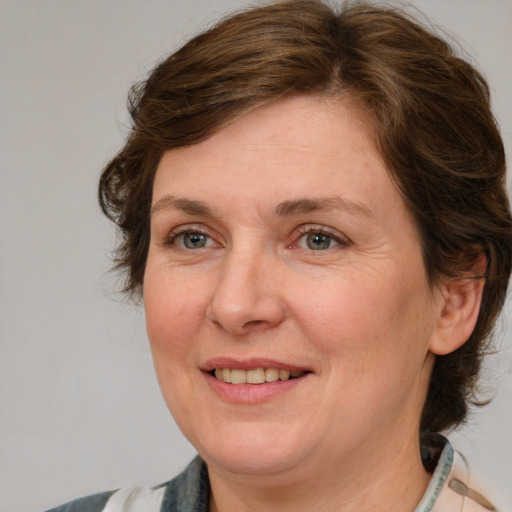 Joyful white adult female with medium  brown hair and blue eyes