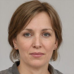 Joyful white adult female with medium  brown hair and grey eyes