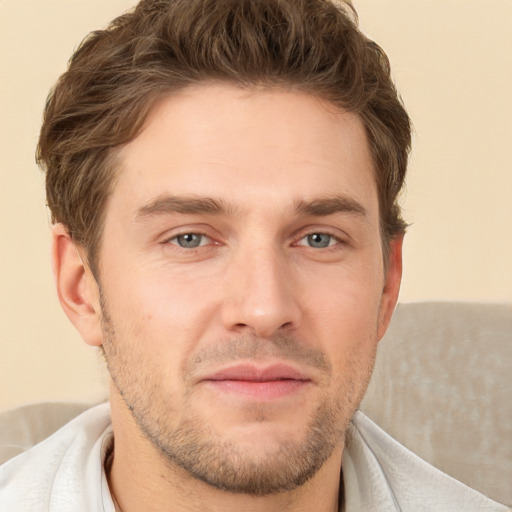 Joyful white young-adult male with short  brown hair and grey eyes