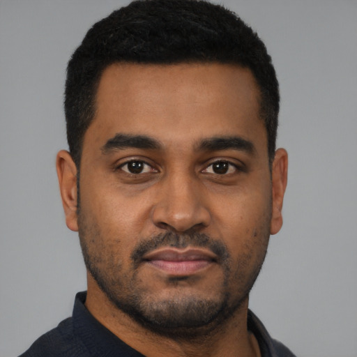 Joyful black young-adult male with short  black hair and brown eyes