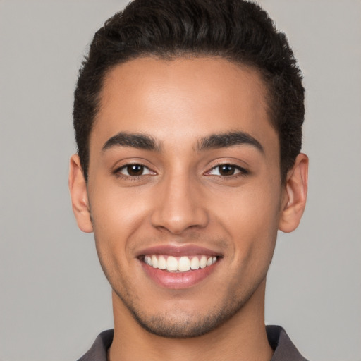 Joyful latino young-adult male with short  brown hair and brown eyes