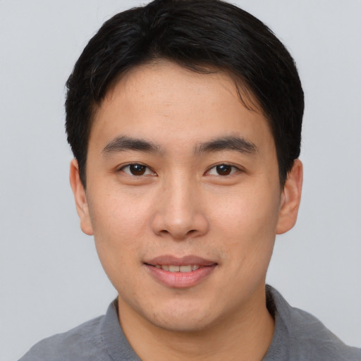 Joyful asian young-adult male with short  brown hair and brown eyes
