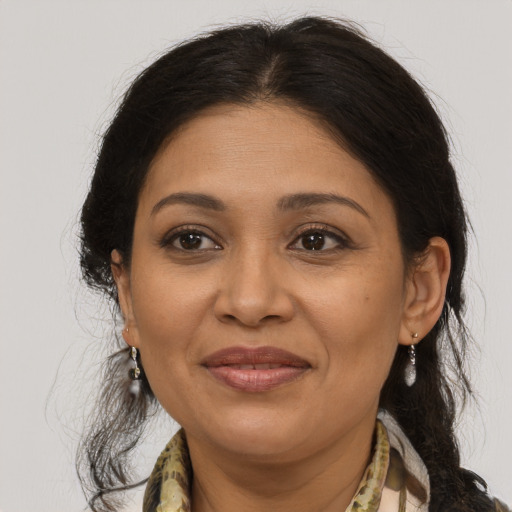 Joyful latino adult female with medium  brown hair and brown eyes