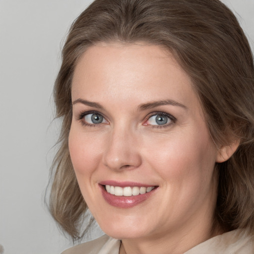 Joyful white young-adult female with medium  brown hair and blue eyes