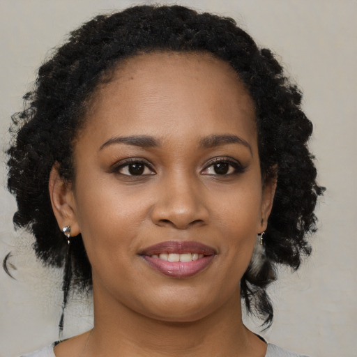Joyful black young-adult female with medium  black hair and brown eyes