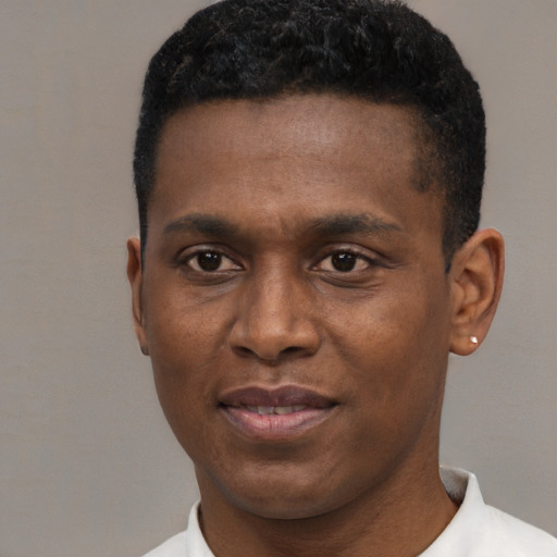 Joyful black young-adult male with short  black hair and brown eyes
