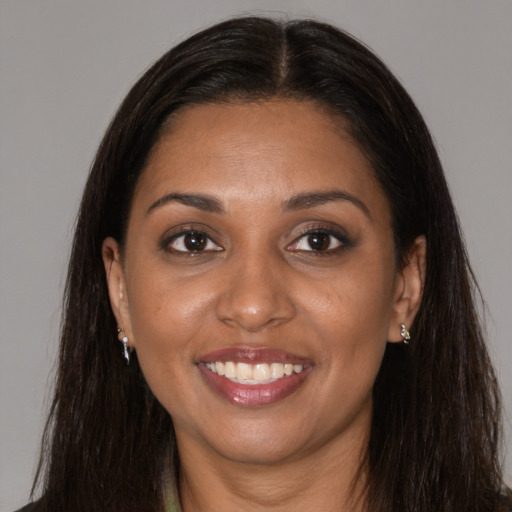 Joyful black young-adult female with long  brown hair and brown eyes
