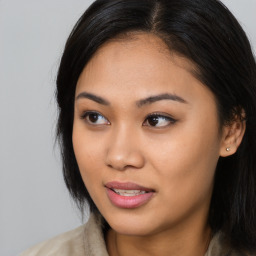 Joyful asian young-adult female with long  brown hair and brown eyes