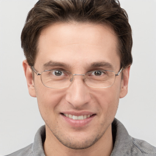 Joyful white adult male with short  brown hair and grey eyes