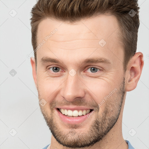 Joyful white young-adult male with short  brown hair and brown eyes