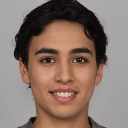 Joyful latino young-adult male with short  brown hair and brown eyes