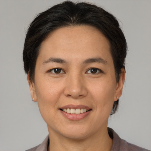 Joyful asian adult female with short  brown hair and brown eyes