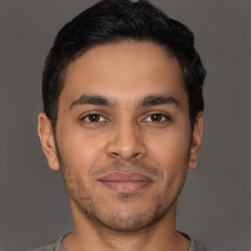 Joyful latino young-adult male with short  brown hair and brown eyes