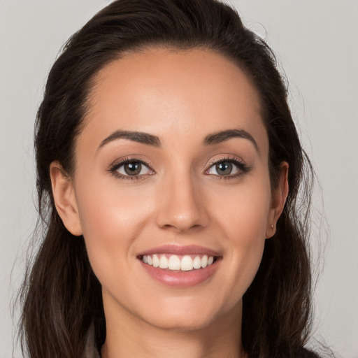 Joyful white young-adult female with long  brown hair and brown eyes