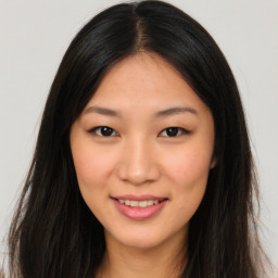 Joyful asian young-adult female with long  brown hair and brown eyes