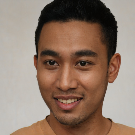 Joyful latino young-adult male with short  black hair and brown eyes