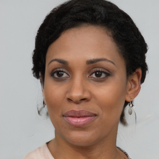Joyful black young-adult female with short  black hair and brown eyes