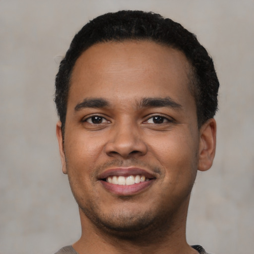 Joyful latino young-adult male with short  black hair and brown eyes