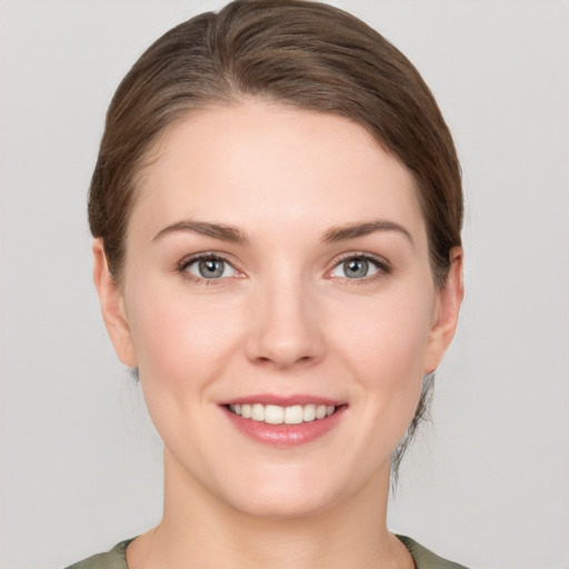 Joyful white young-adult female with medium  brown hair and grey eyes