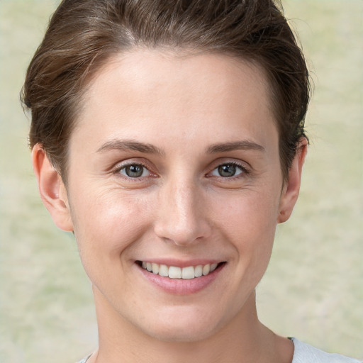 Joyful white young-adult female with short  brown hair and grey eyes