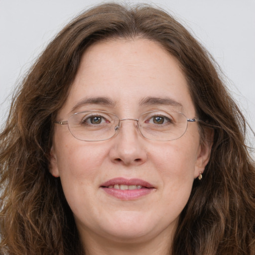 Joyful white adult female with long  brown hair and green eyes