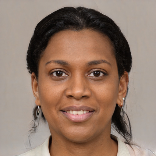 Joyful black young-adult female with medium  black hair and brown eyes