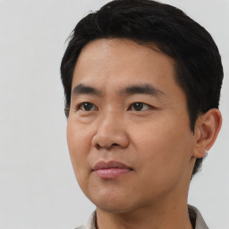 Joyful asian young-adult male with short  black hair and brown eyes