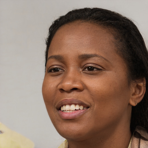 Joyful black young-adult female with long  brown hair and brown eyes