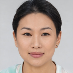 Joyful asian young-adult female with short  brown hair and brown eyes