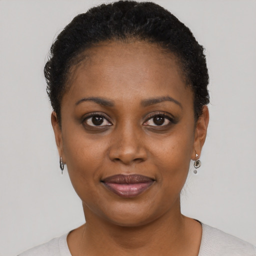 Joyful black young-adult female with short  black hair and brown eyes