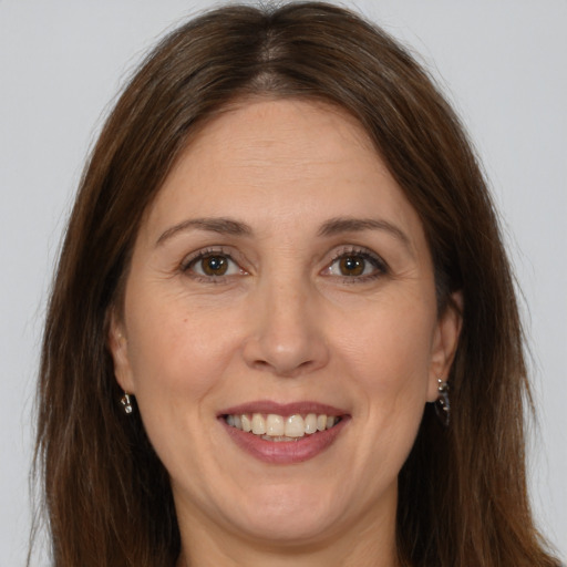 Joyful white adult female with long  brown hair and brown eyes