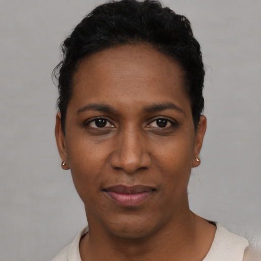 Joyful black young-adult female with short  black hair and brown eyes