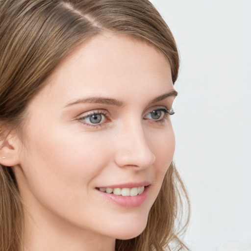 Joyful white young-adult female with long  brown hair and blue eyes