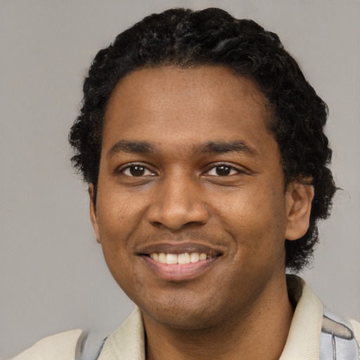 Joyful black young-adult male with short  black hair and brown eyes