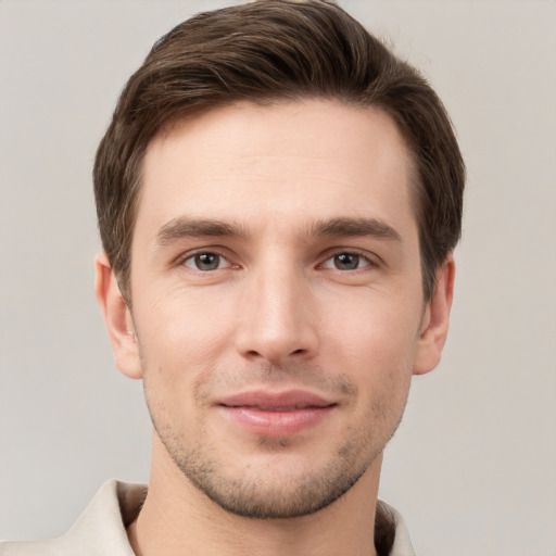 Joyful white young-adult male with short  brown hair and grey eyes