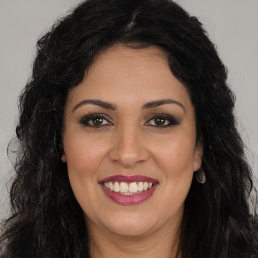 Joyful latino young-adult female with long  brown hair and brown eyes