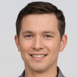 Joyful white young-adult male with short  brown hair and brown eyes