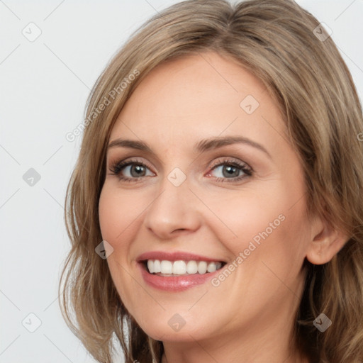 Joyful white young-adult female with long  brown hair and blue eyes