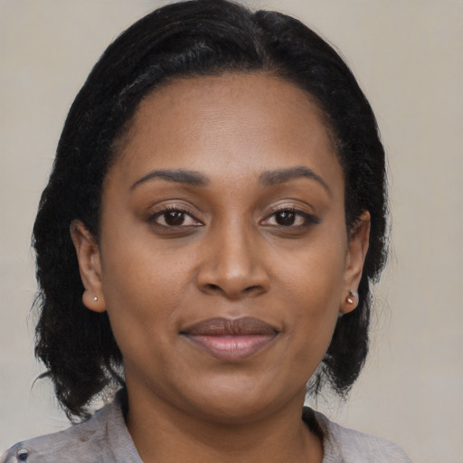 Joyful black young-adult female with medium  black hair and brown eyes