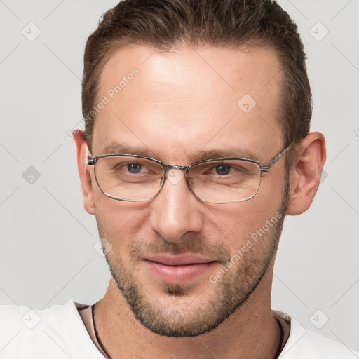 Joyful white adult male with short  brown hair and grey eyes