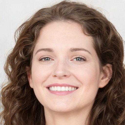 Joyful white young-adult female with long  brown hair and green eyes