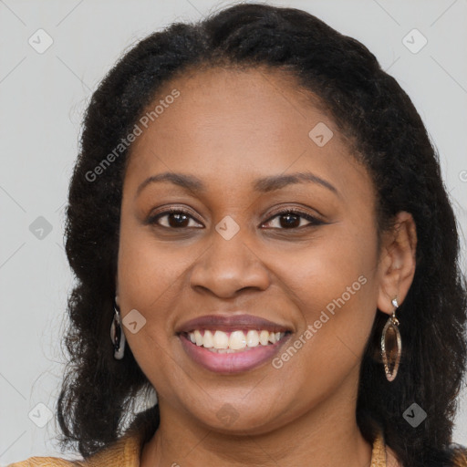 Joyful black young-adult female with long  brown hair and brown eyes